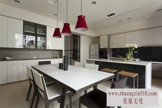 白色厨具增添采光面,加上红色造型吊灯呼应客厅茶几,点亮了空间。简单的设计线条里蕴藏了水槽、电器柜等大容量的收纳空间。